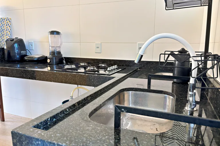 Cozinha com bancada de granito cooktop e eletros