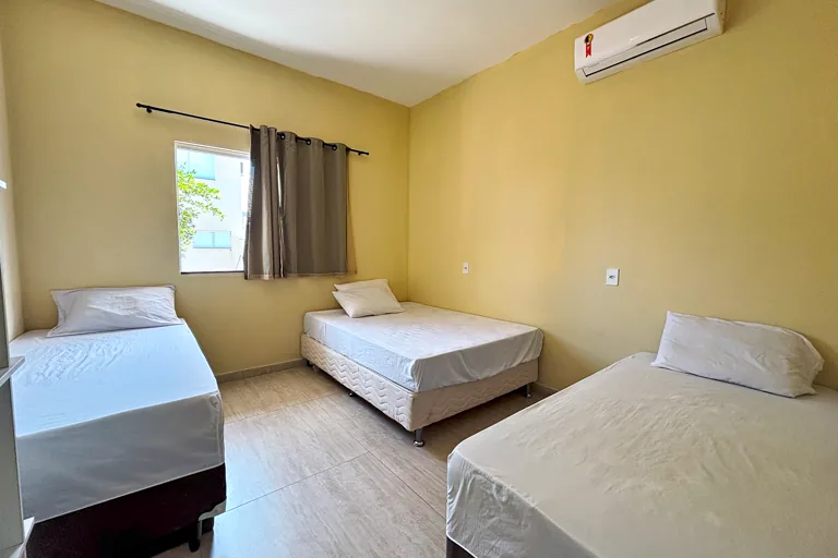 Quarto com tres camas ar-condicionado e janela