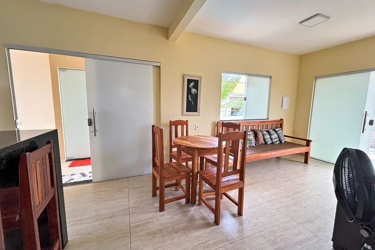 Mesa de jantar e sofa de madeira com portas de correr integrando os ambientes