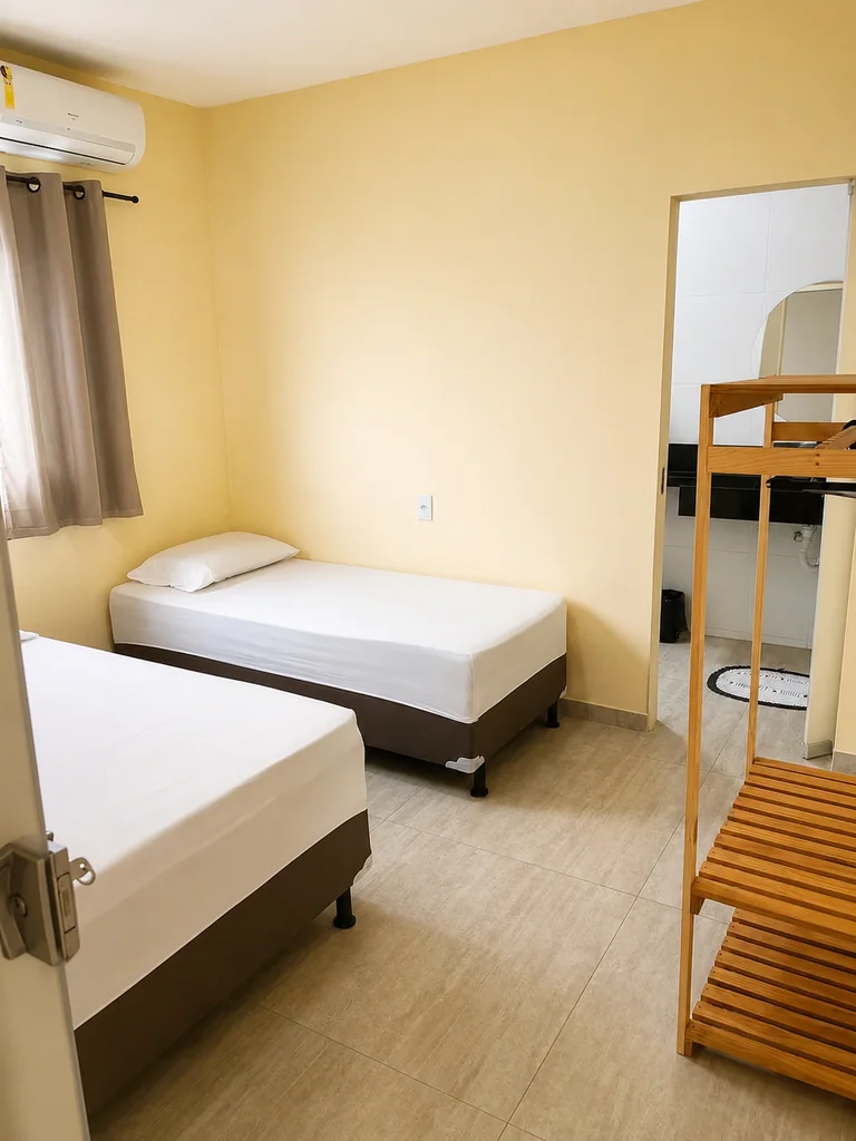 Quarto com duas camas de solteiro, beliche de madeira e ar-condicionado