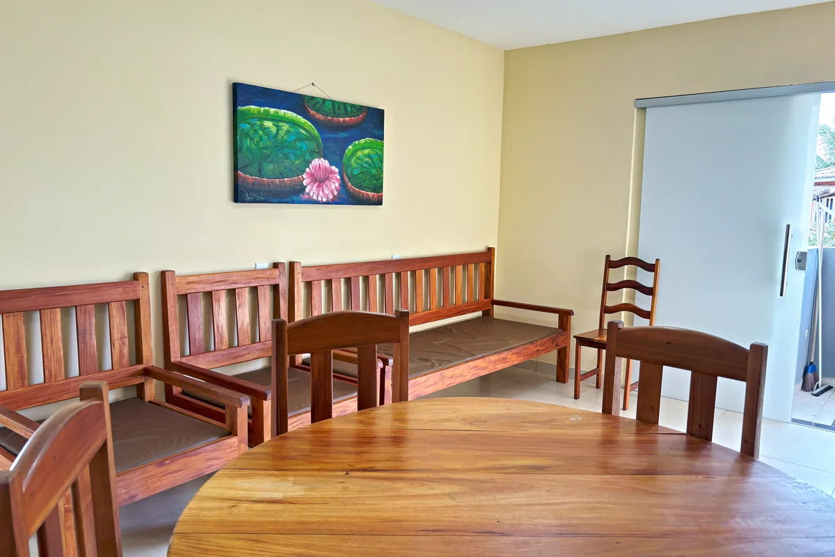 Mesa de jantar e bancos de madeira na sala da Hortelã