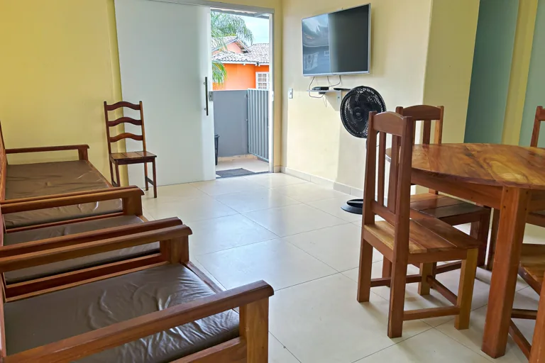 Sala com bancos sofa TV e porta de correr para area externa