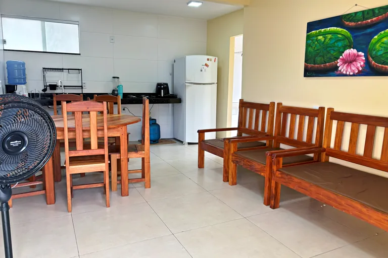Cozinha equipada com cooktop geladeira e bebedouro integrada a sala