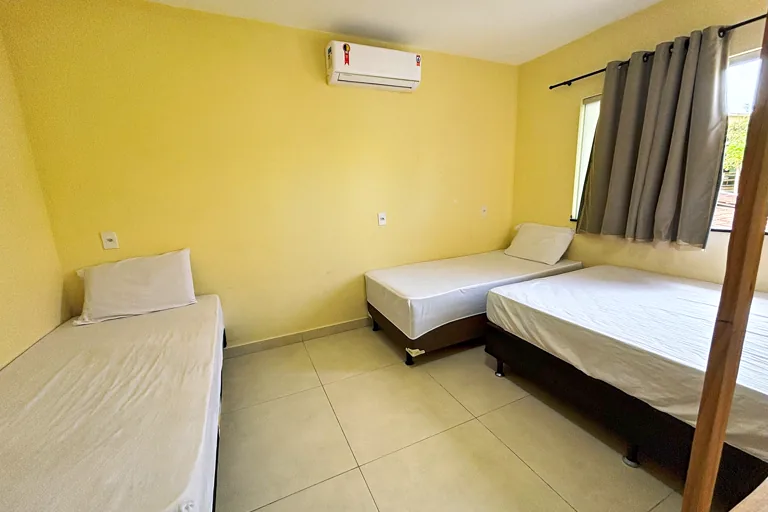 Quarto com tres camas de solteiro ar condicionado split e cortina blackout