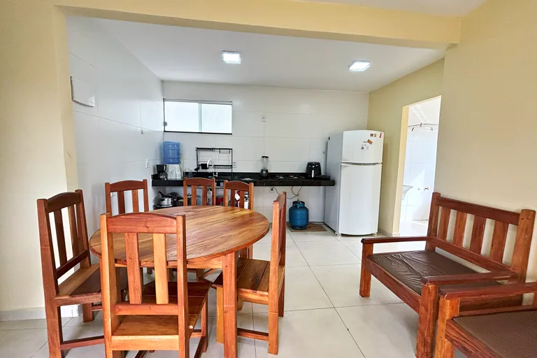 Mesa de jantar redonda integrada a cozinha com banco de madeira