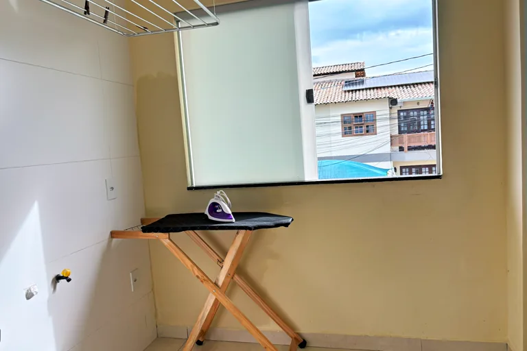 Area de servico com varal de teto tabua de passar e janela iluminada