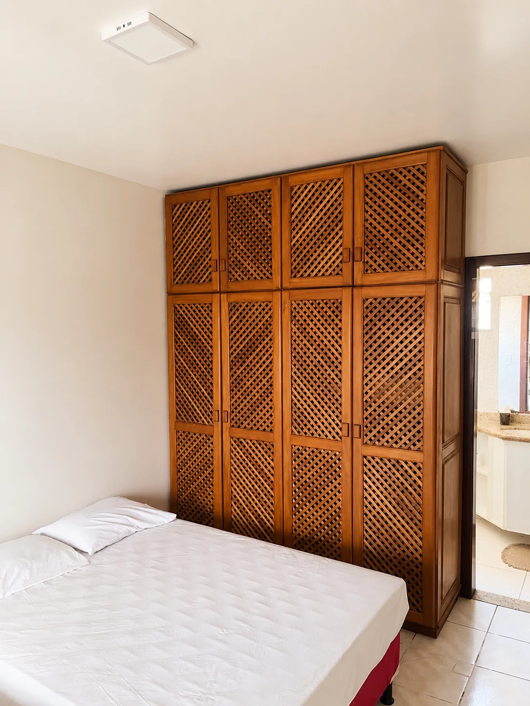 Suite da Casa Naira com cama de casal, ar-condicionado e roupa de cama clara