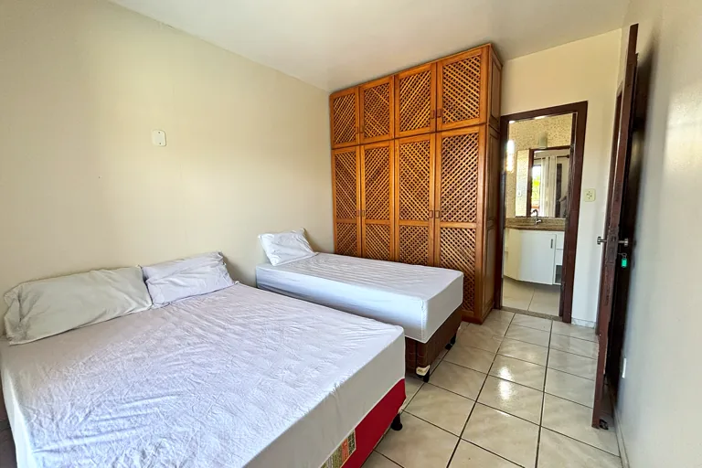 Quarto com cama de casal cama de solteiro e grande armario de madeira com suite ao fundo