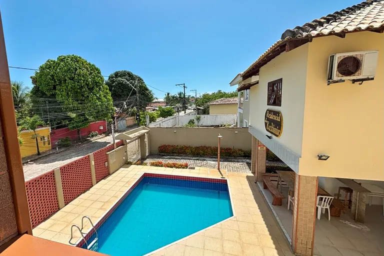 Vista da varanda da casa para a piscina e a área coberta