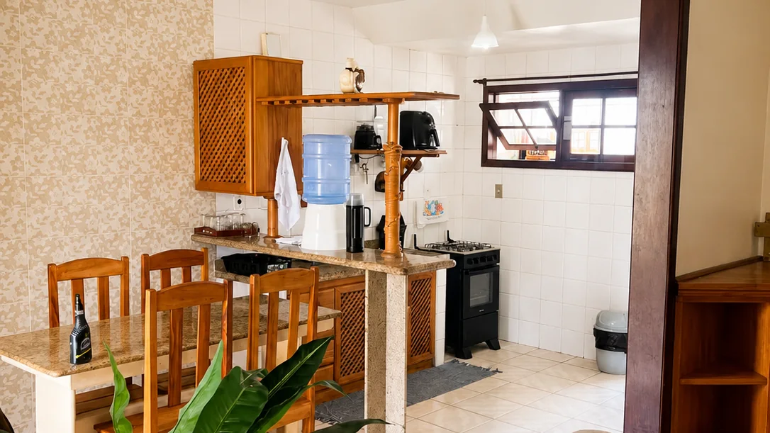 Sala integrada da Casa Naira com sofa, area de estar e cozinha ao fundo