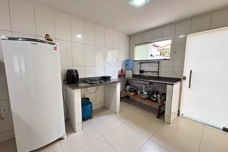 Cozinha com geladeira, cooktop, pia e bebedouro