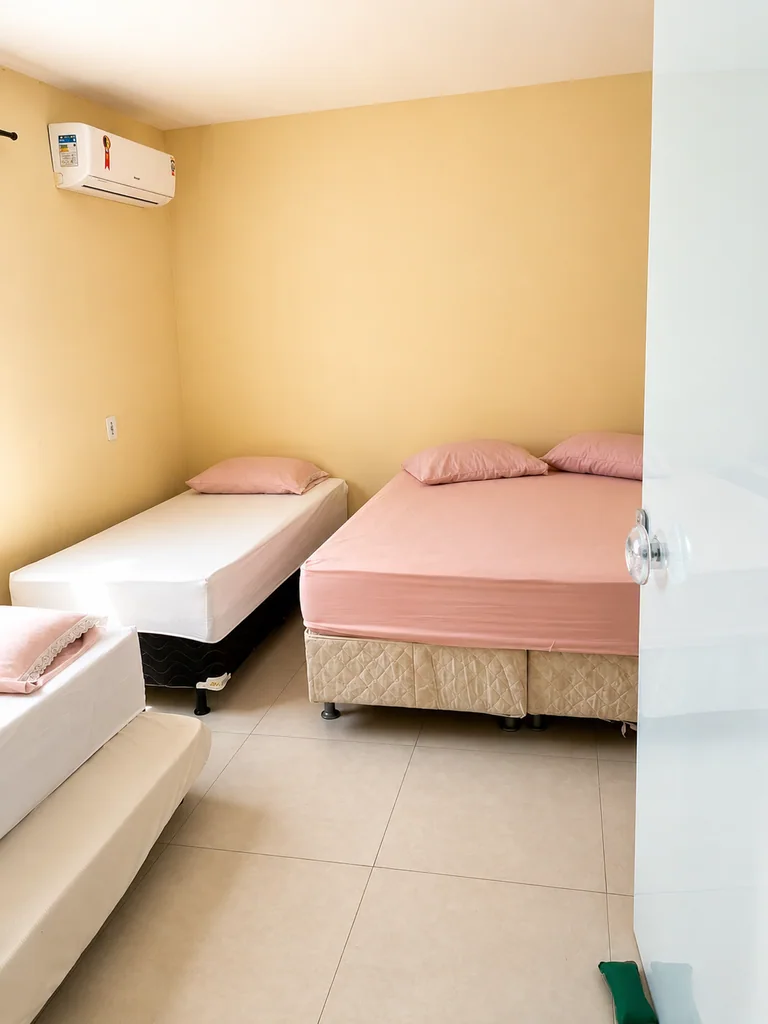 Quarto com cama de casal, cama de solteiro e ar-condicionado