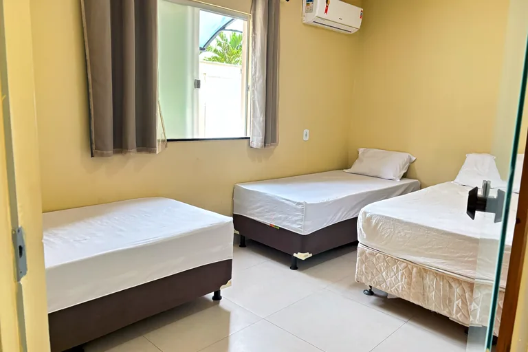 Quarto amplo com tres camas e ar-condicionado split
