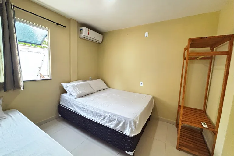 Quarto de casal com arara de madeira e ar-condicionado