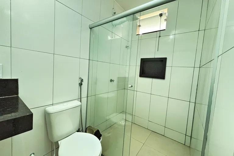 Banheiro com vaso e box de vidro espacoso